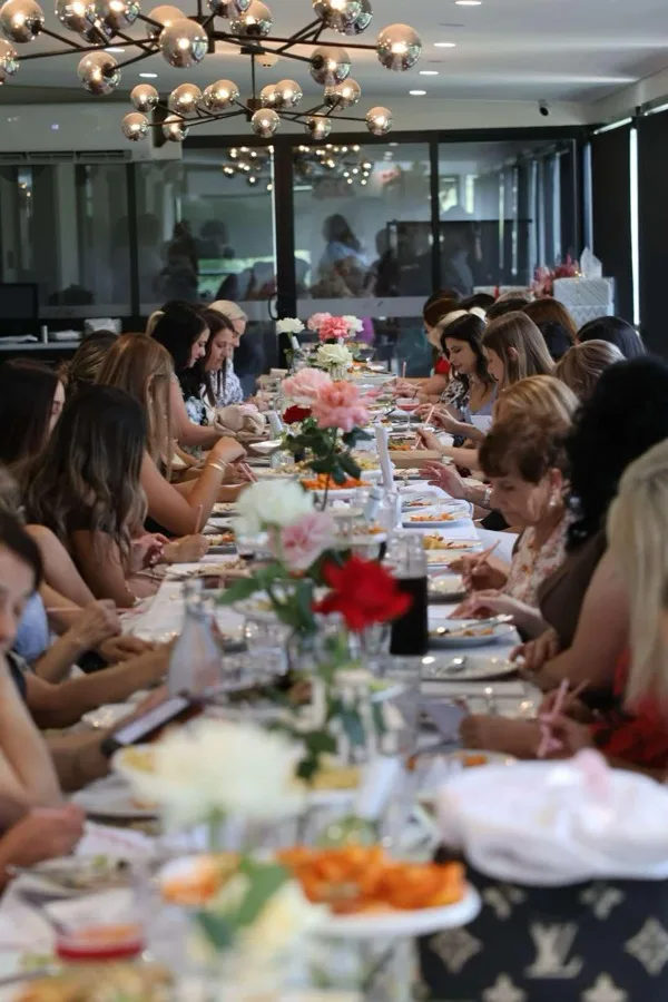 Bridal shower long table styled with fresh florals and pendant lighting