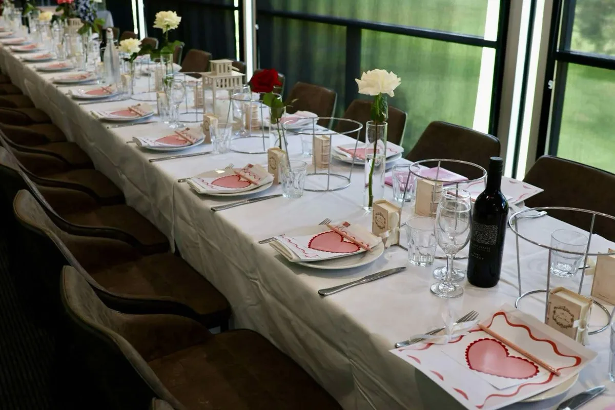 Valentine’s themed long table styling with red roses, heart place cards and lantern centrepieces